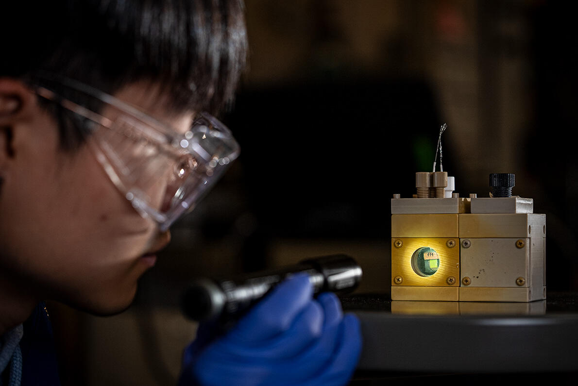 Scientist shining light on a device.