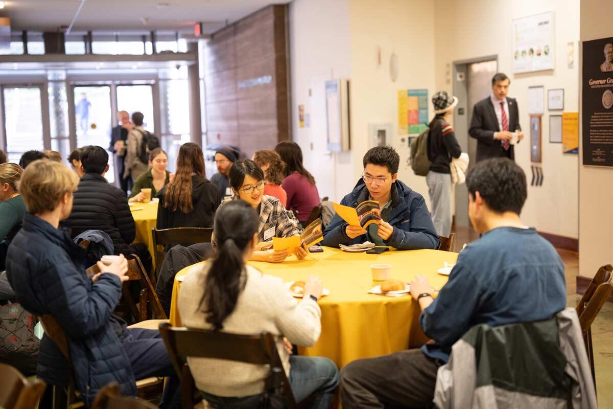 College students sitting at tables at an event.