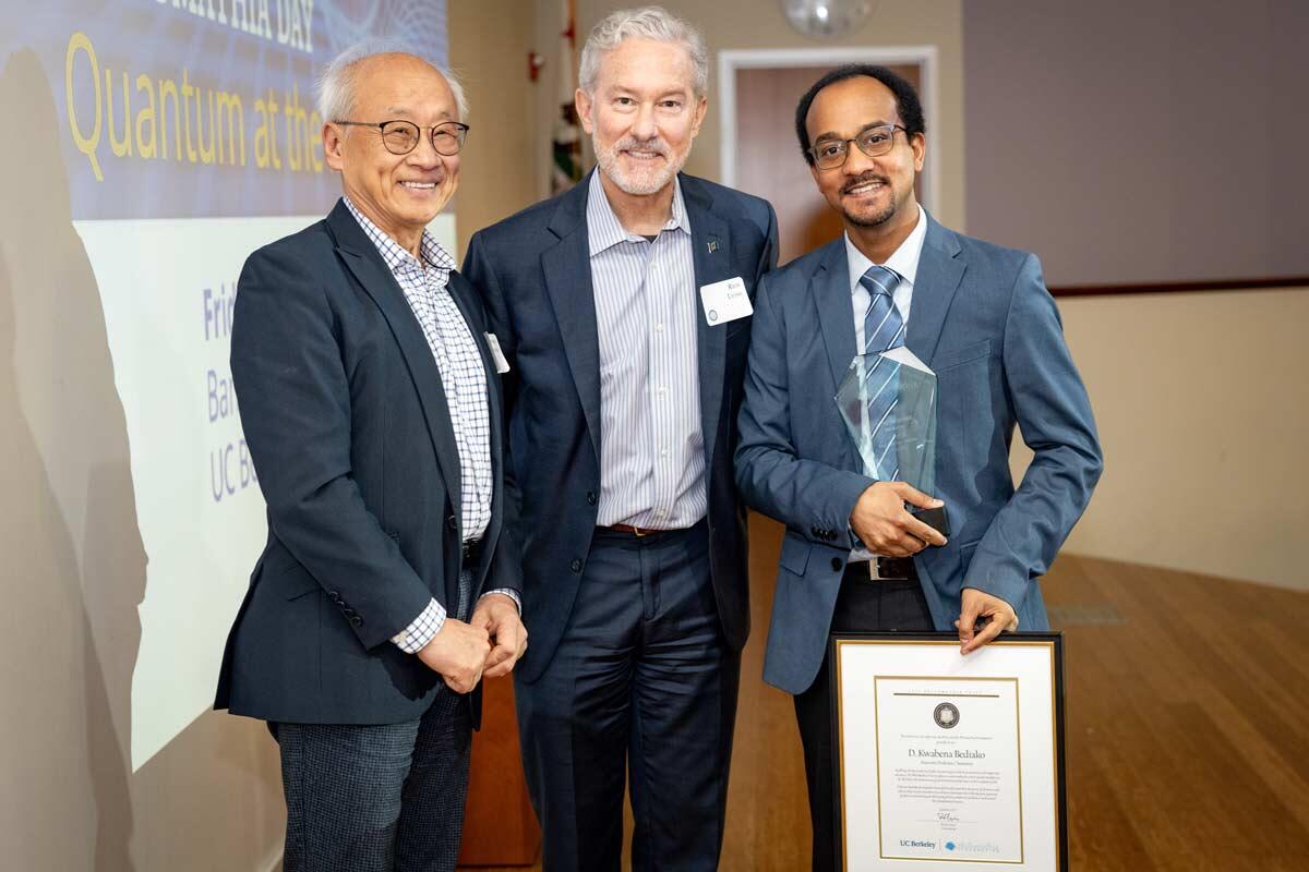 Three people at an awards ceremony.