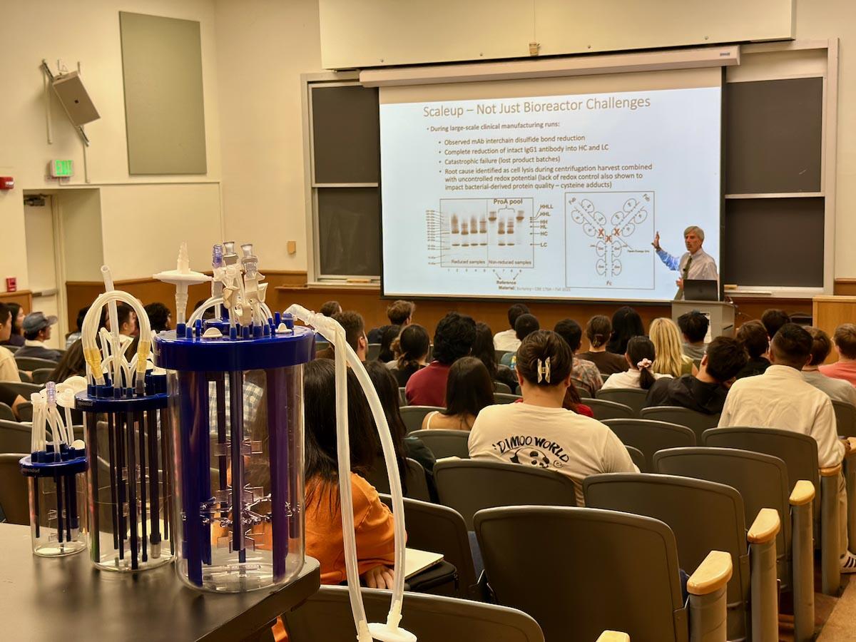A Professor teaching in a lecture hall filled with students.