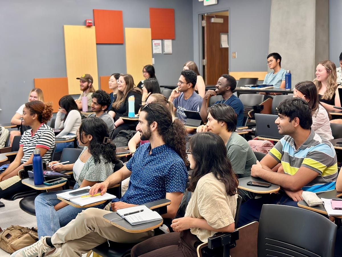 Students in a lecture hall, many of them smiling.