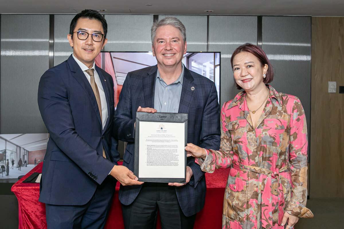 3 people smiling and holding a signing letter