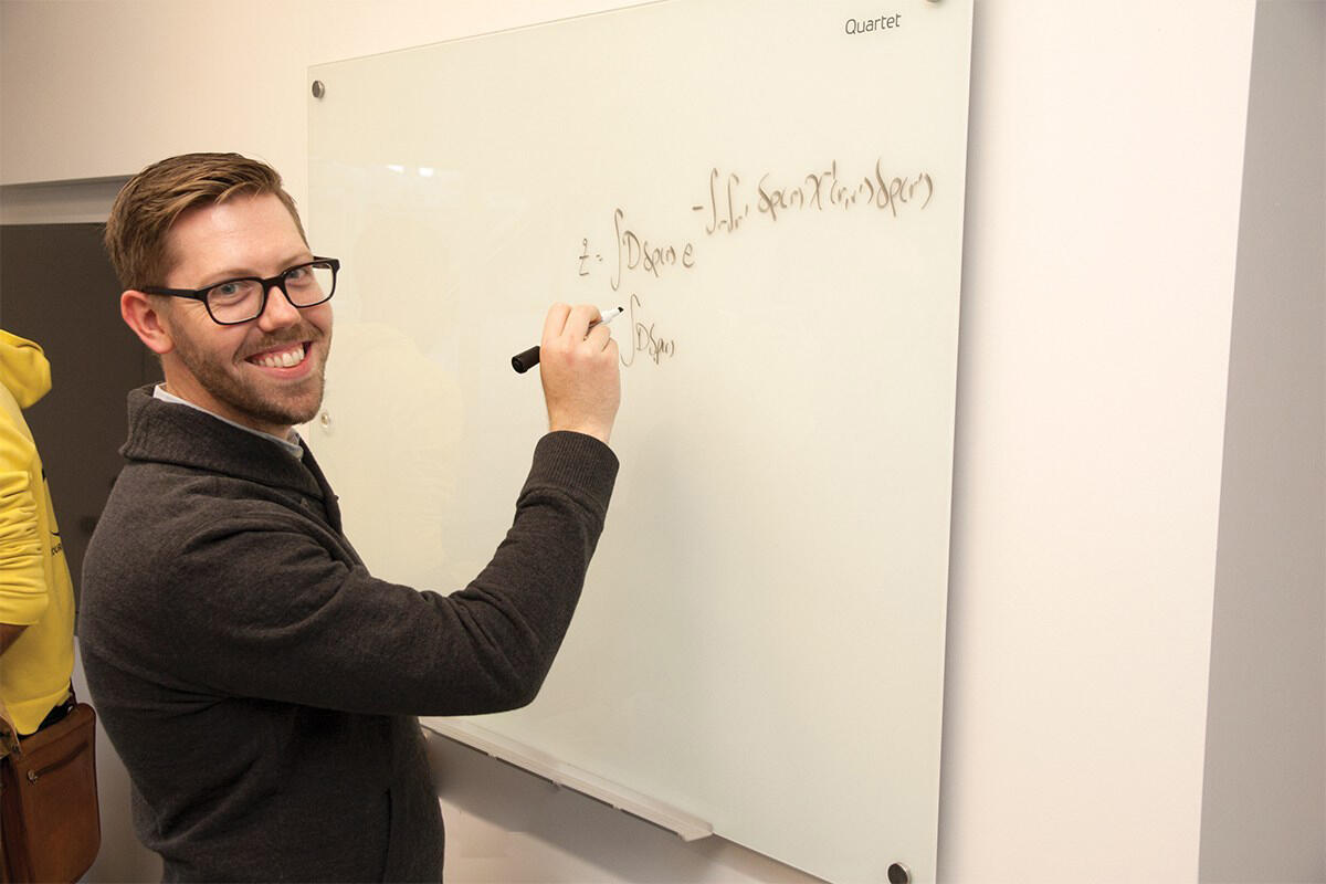 Professor writing on whiteboard