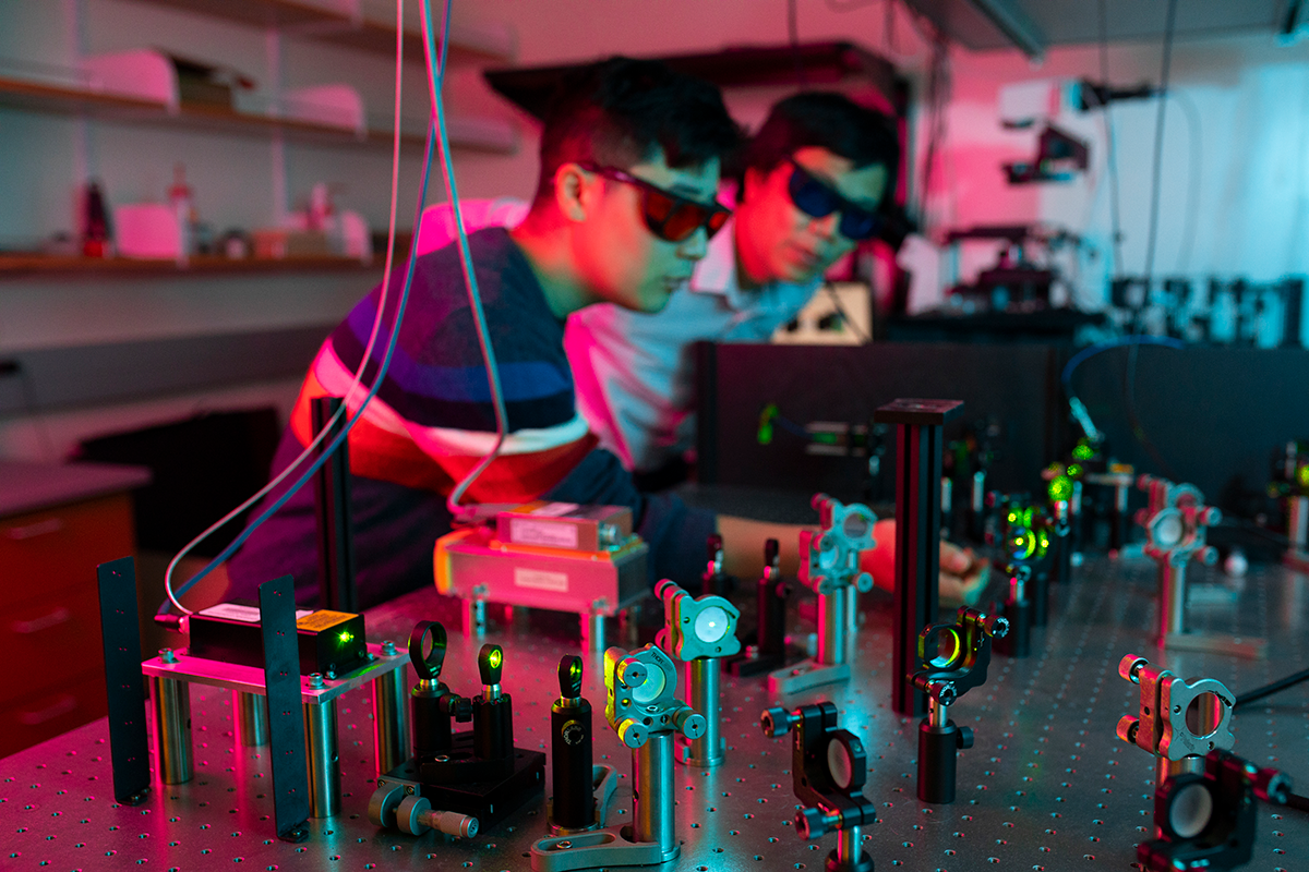 Ke Xu and PhD candidate Alex Choi adjust lasers that can help visualize the microscopic movements of molecules (Photo by Elena Zhukova)